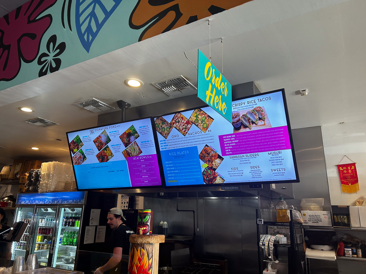 counter with digital menu on tv screens with bright colors